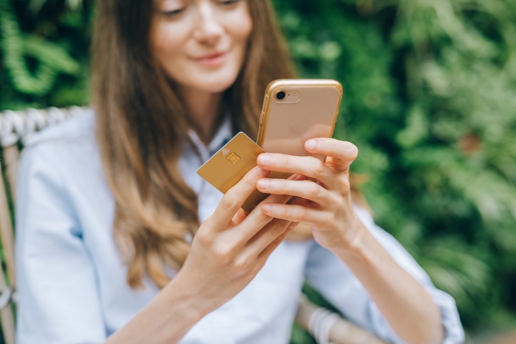 woman holding credit card and iPhone